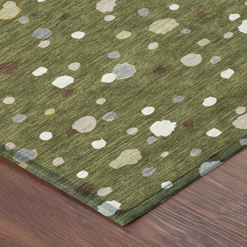 Olive green area rug corner close-up with white oval and irregular geometric speck pattern