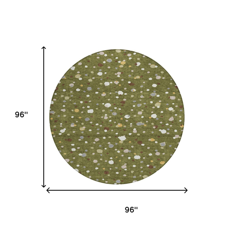 Round olive green rug with off-white dots and multicolor speckled spots