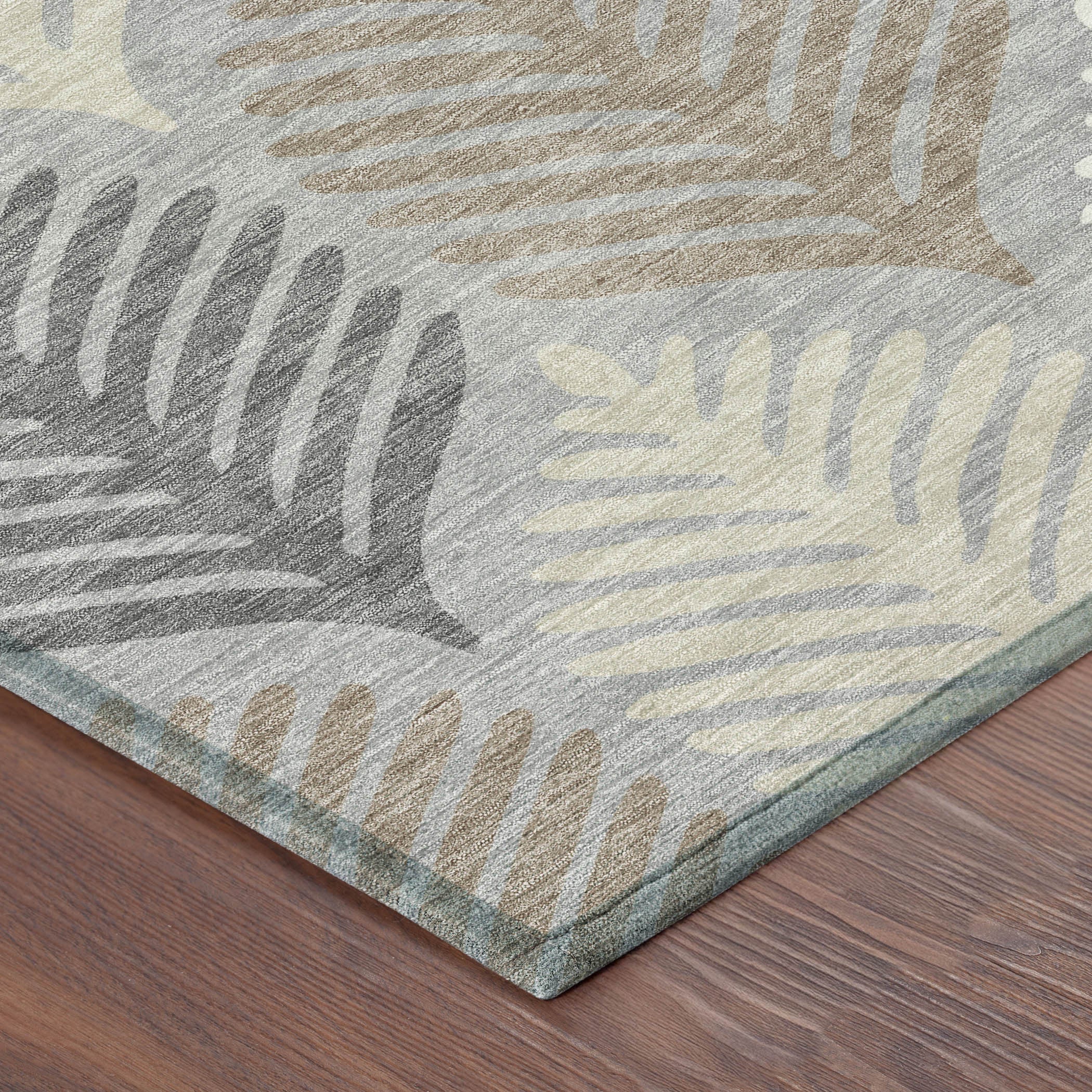 Gray and beige leaf pattern area rug with textured border corner