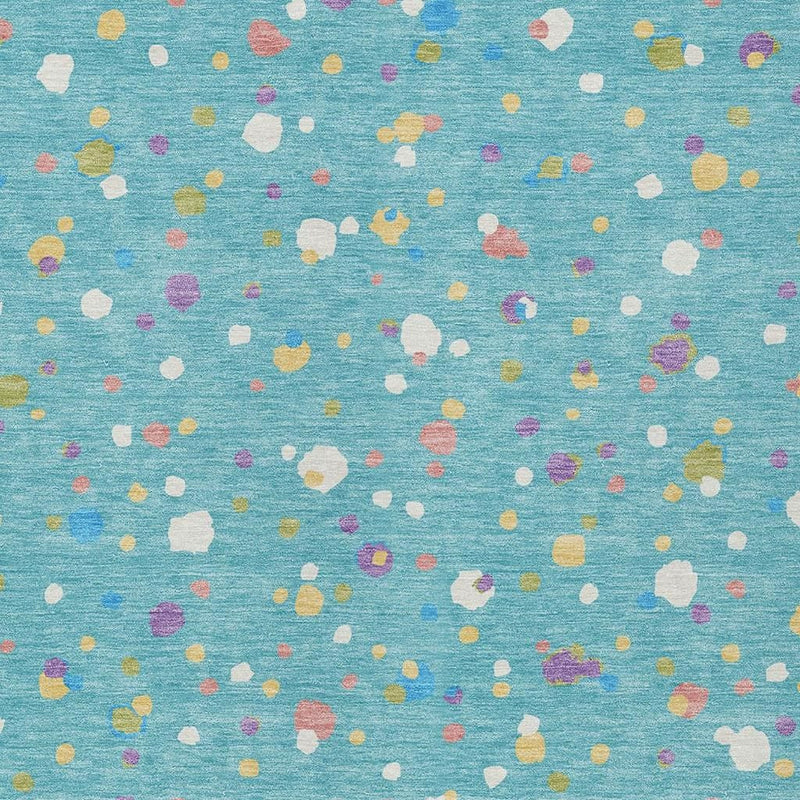 Teal blue area rug featuring small multicolor geometric shapes across the surface