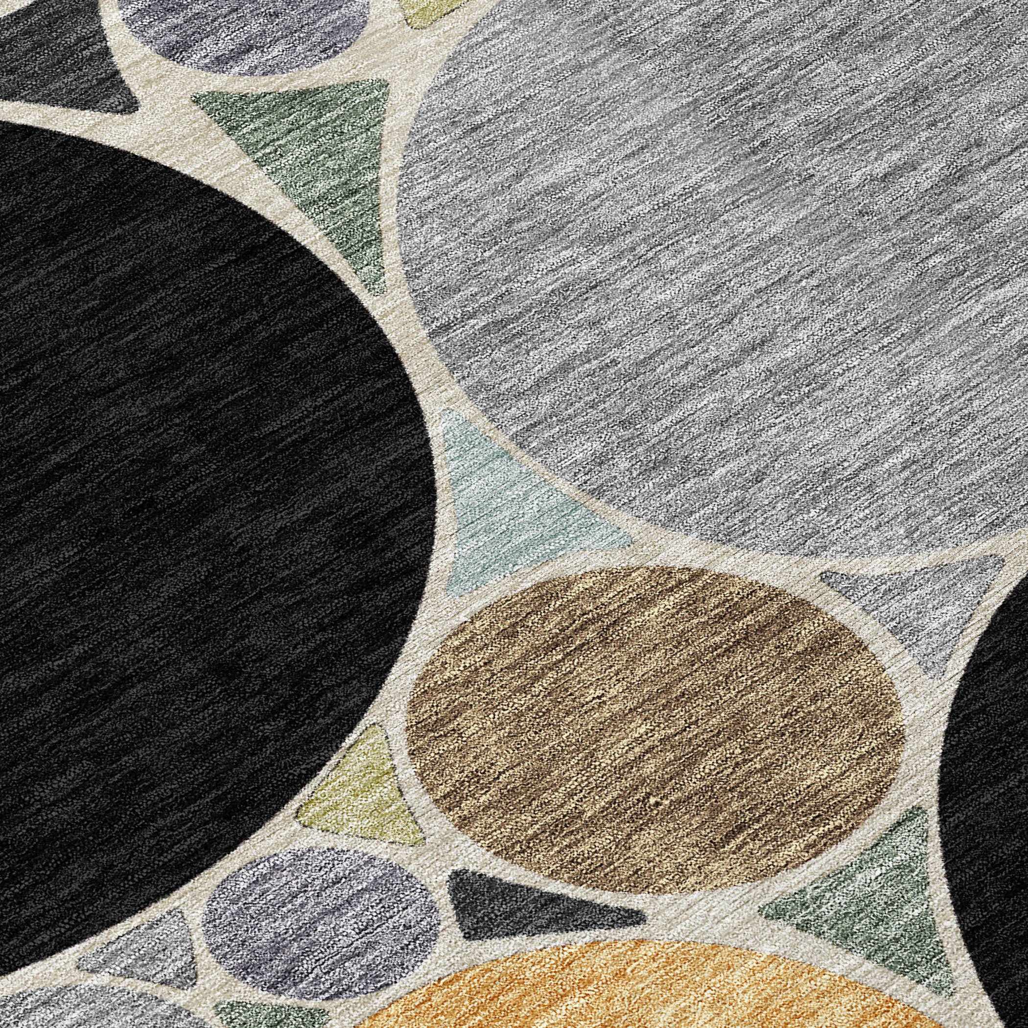 Geometric area rug close-up with black, gray, and gold ovals and teal accents