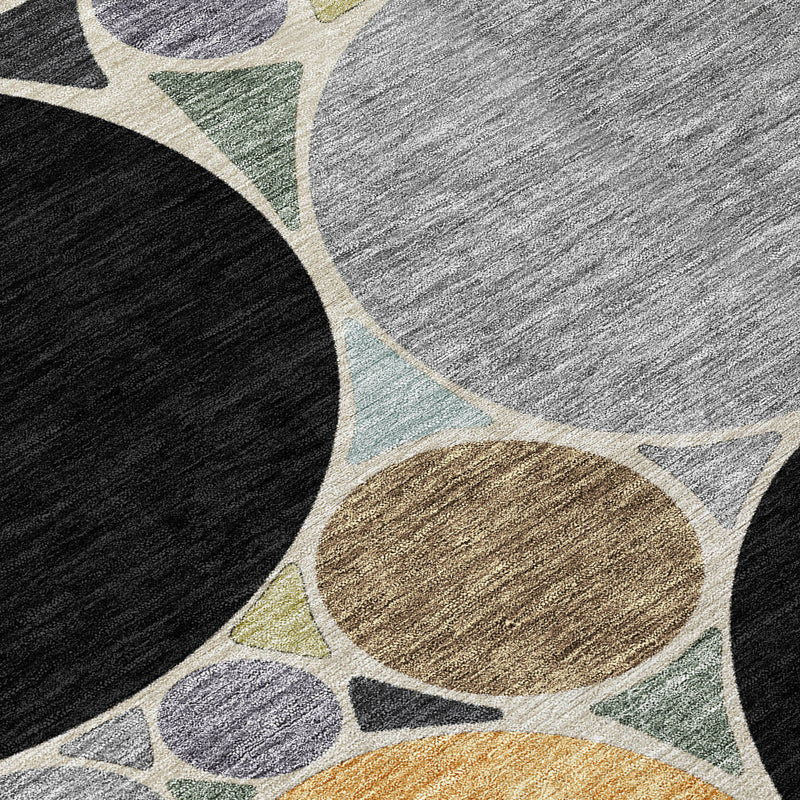 Geometric area rug close-up with black, gray, and gold ovals and teal accents