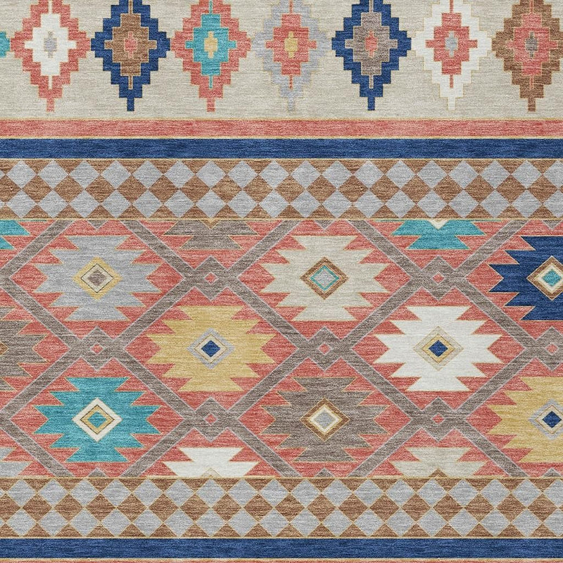 Close-up of southwestern rug pattern with diamond, cross, and zigzag shapes in coral and teal.