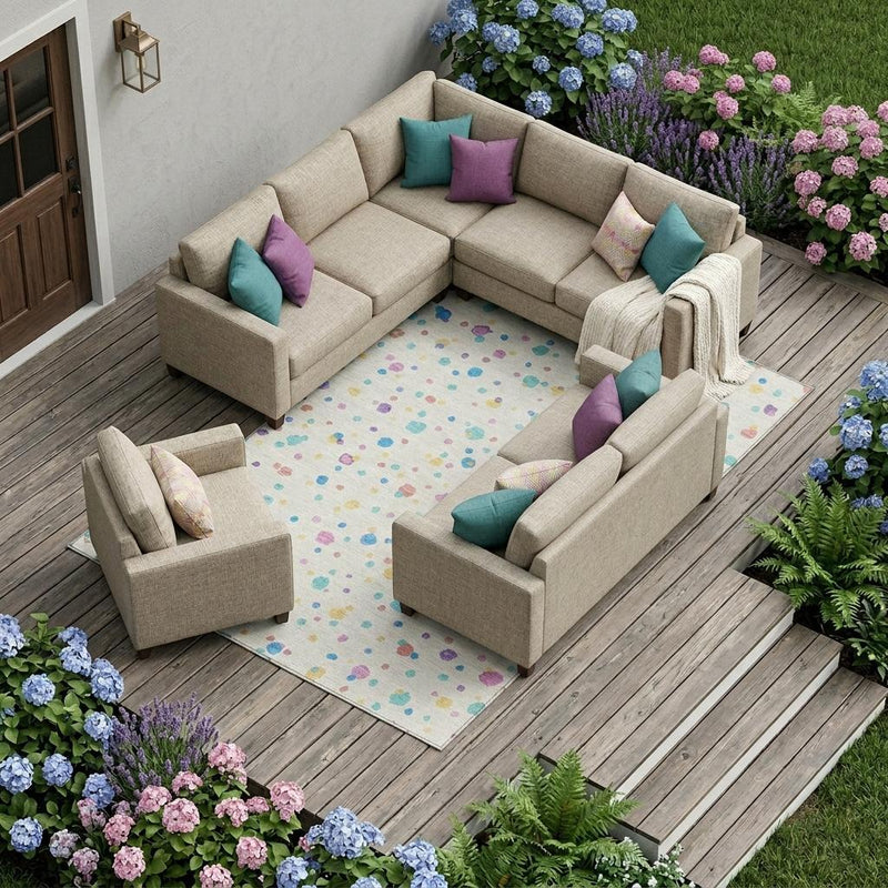 Ivory geometric area rug with colorful speckled pattern visible under outdoor seating