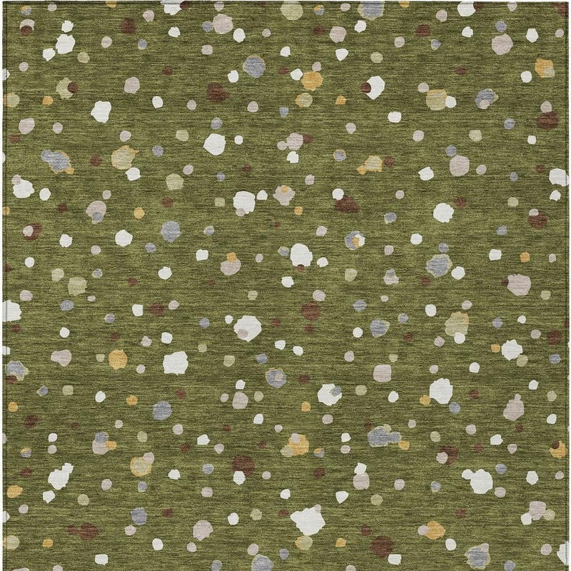 Olive green area rug with dense white geometric specks and small muted colors