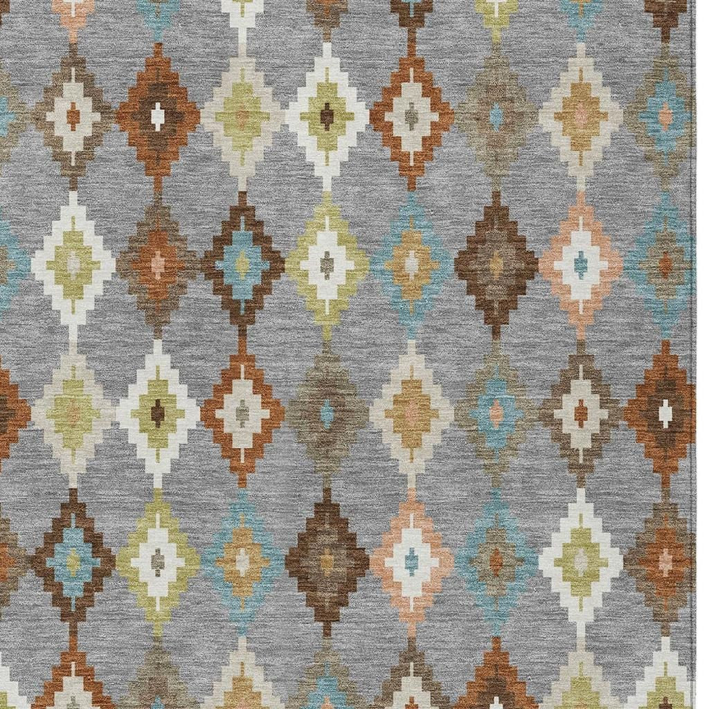 Gray aztec rug close-up with beige, brown, blue, and orange diamond shapes