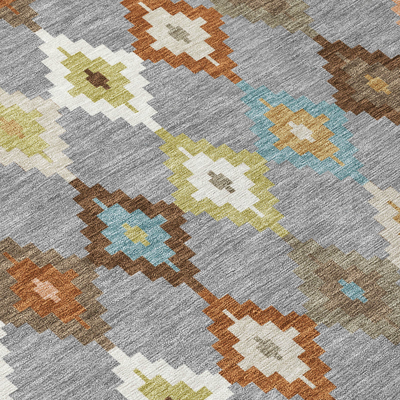 Close-up of gray aztec area rug with blue, lime, and orange diamond motifs