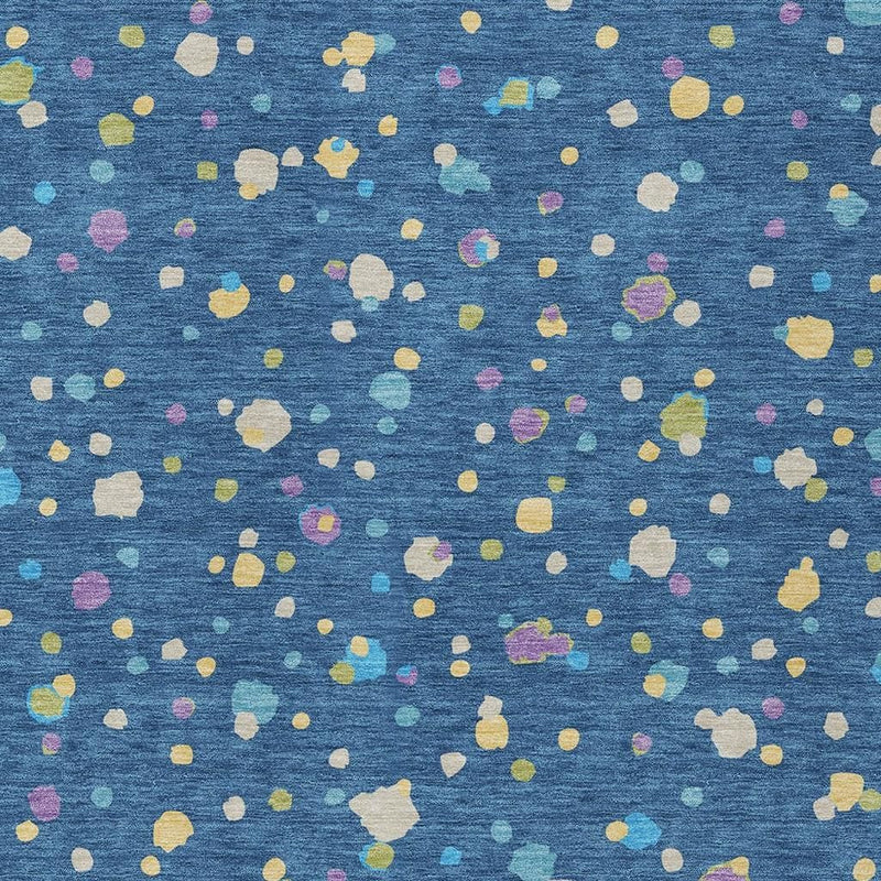 Close-up of navy area rug with scattered multicolor geometric dots and irregular shapes