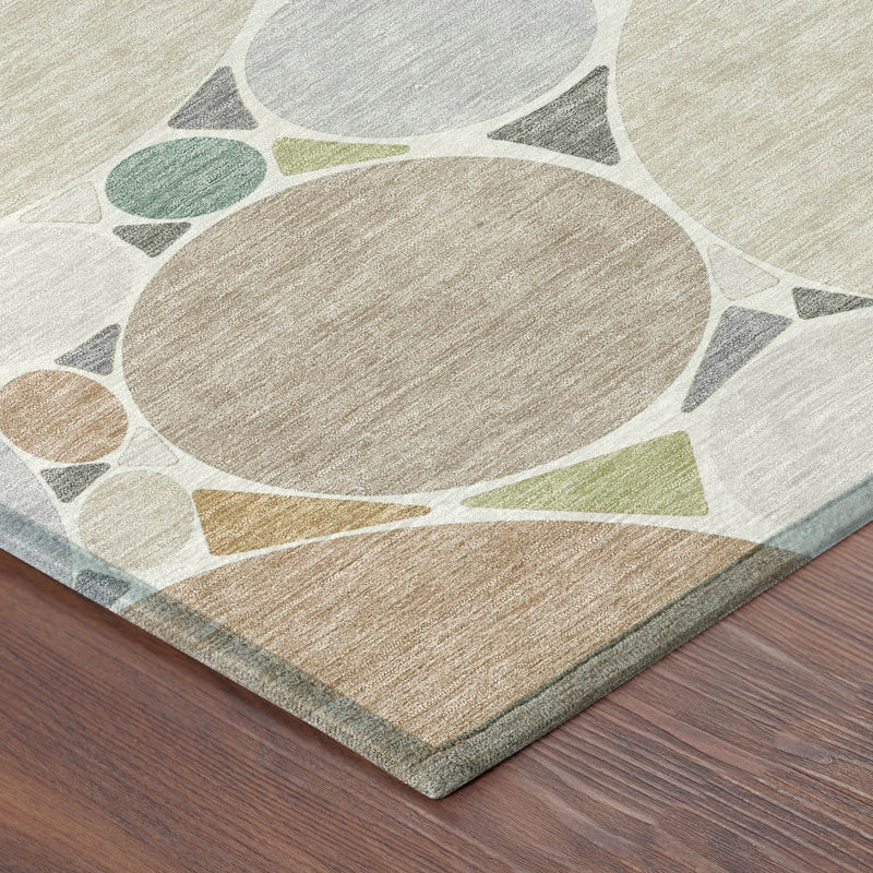 Corner of beige and gray geometric area rug with circular motifs and stitched edge