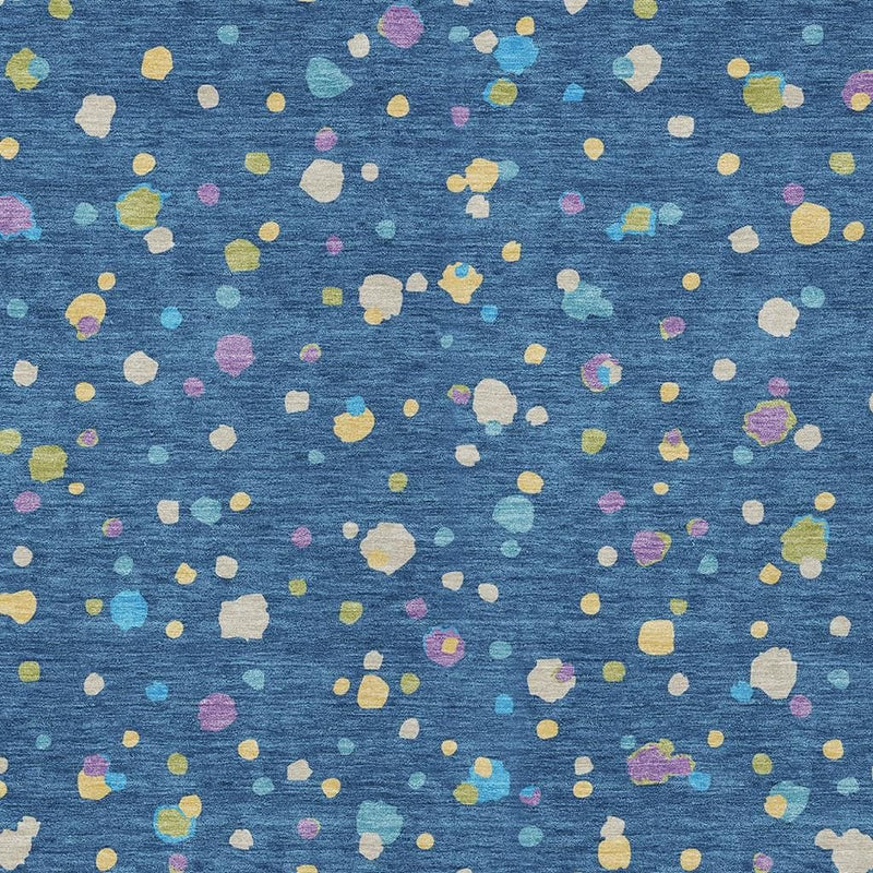 Navy blue area rug with scattered ivory, yellow, pink, and green geometric speckles