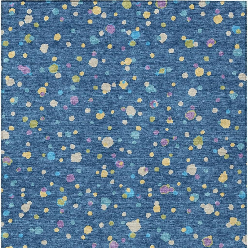 Close-up navy blue area rug with scattered ivory, yellow, purple, and green speckles