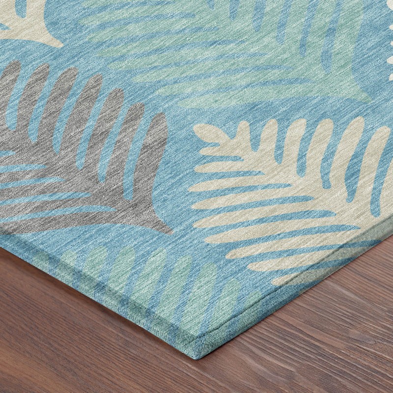Teal blue rug corner with ivory and gold leaf motif on textured surface