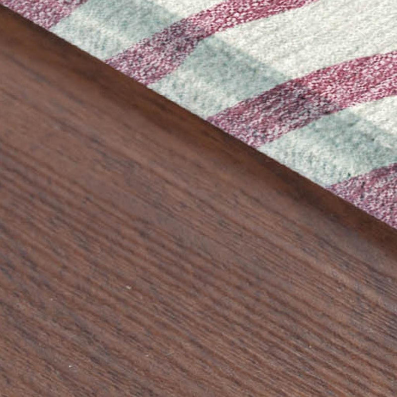 Corner view of pink and ivory zebra stripe rug with flat, low-pile weave