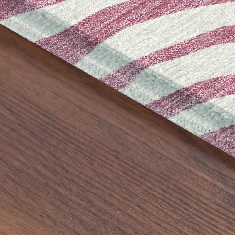 Edge detail of pink and ivory zebra stripe rug on wood flooring