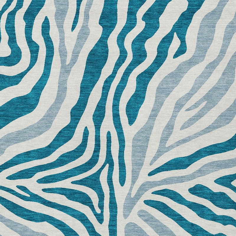 Close-up of teal blue zebra wavy stripes on an ivory indoor outdoor area rug