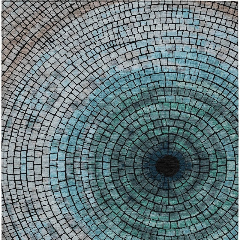 Close-up teal and gray spiral mosaic area rug with dark center medallion