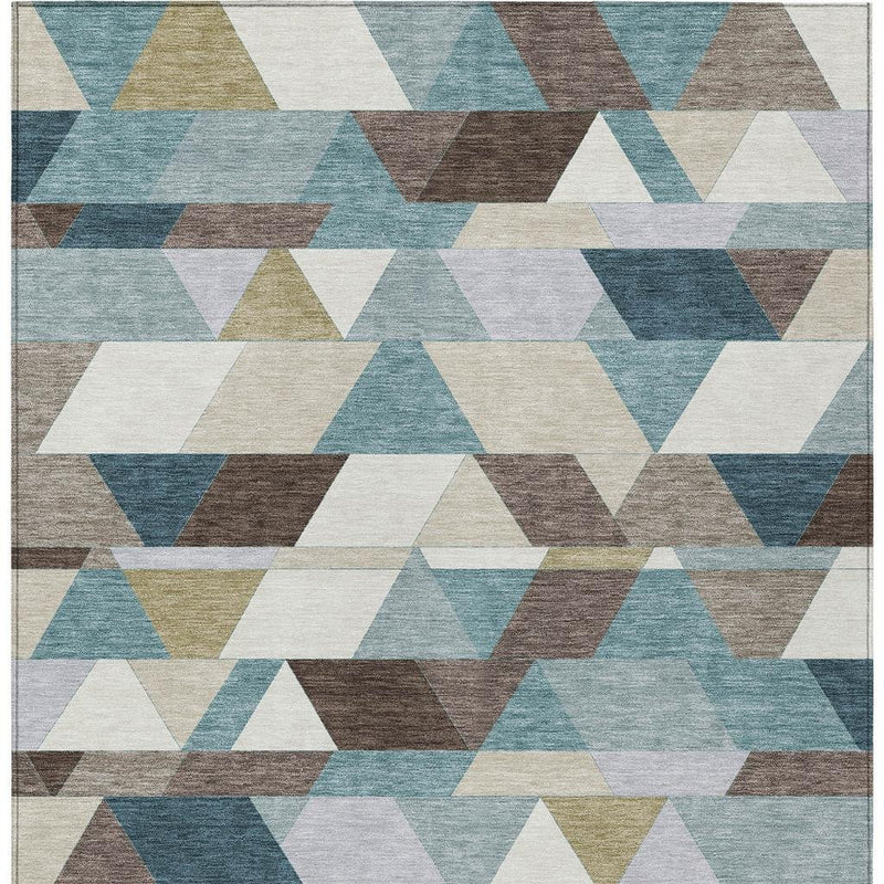 Close-up geometric rug pattern in teal blue, pale aqua, brown, cream, and gray