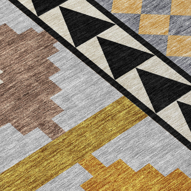 Geometric area rug close-up with black stripe pattern and layered beige, gray, and mustard shapes