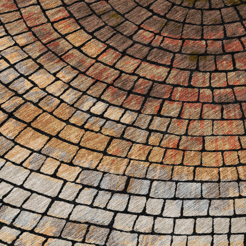 Close-up geometric rug showing brick-like grid pattern in cream, copper, orange, and blue