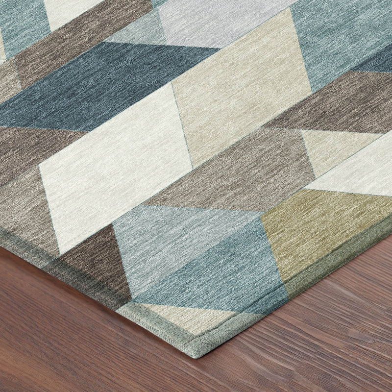 Corner of geometric area rug with teal, pale aqua, cream, and brown triangle blocks