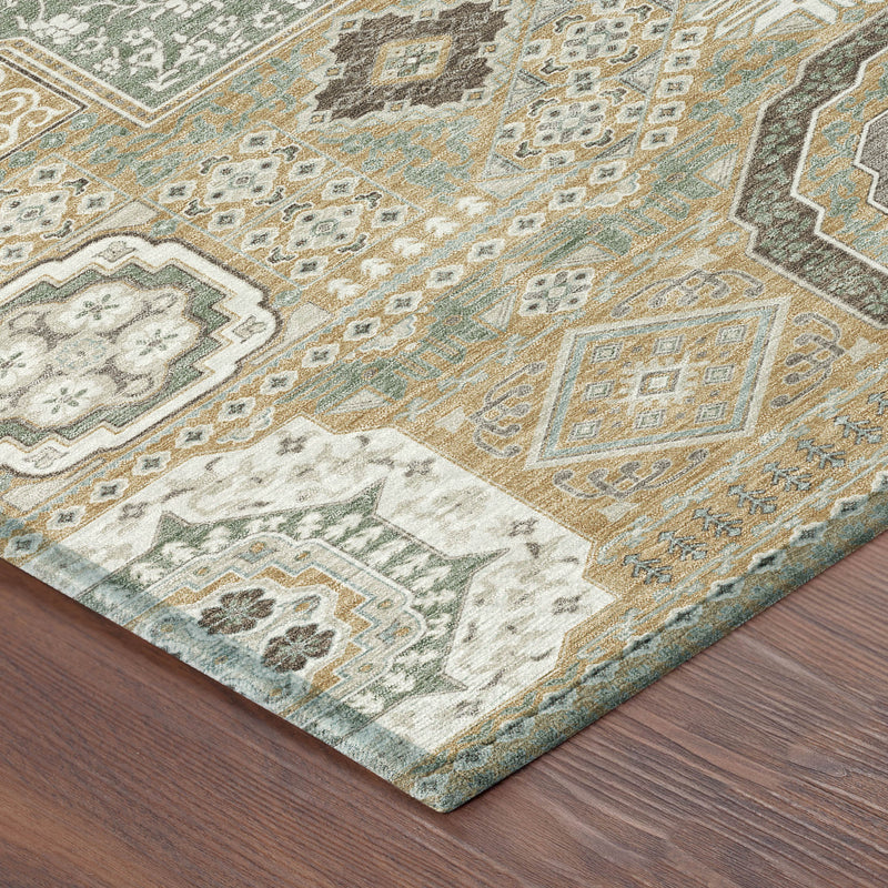 Corner view of gold and sage area rug with ornate patchwork motifs and border