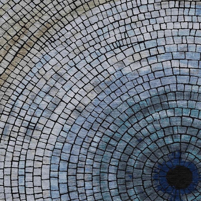 Close-up of denim blue geometric rug with concentric brick rings and dark spiral center