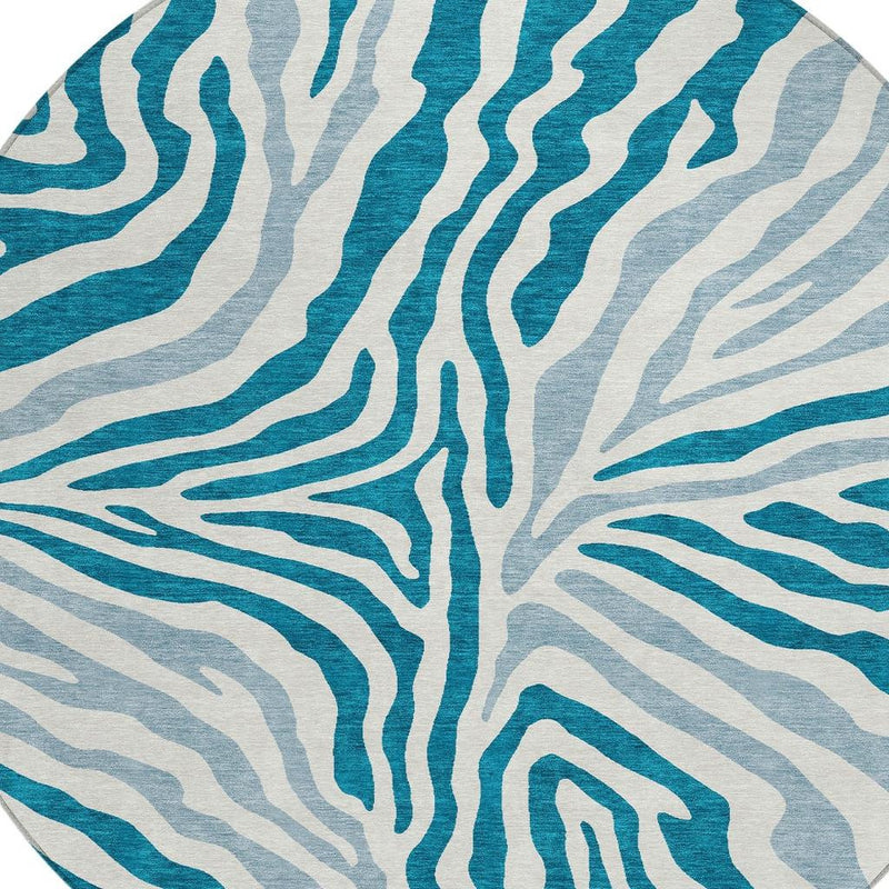 Close-up of teal and ivory zebra stripe pattern on a round washable area rug
