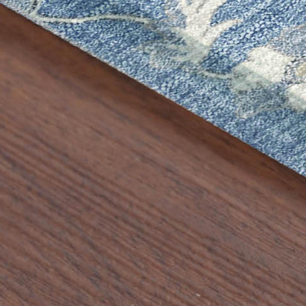 Blue floral-patterned area rug with a textured design on a wooden floor. Perfect for modern home decor.