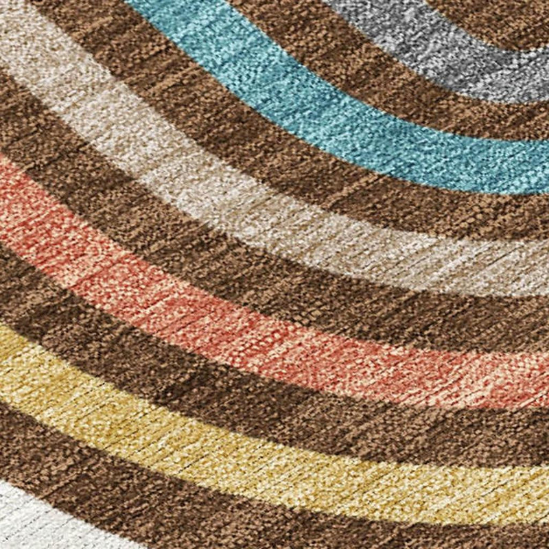Close-up of geometric rug texture with brown and ivory stripes and teal, coral, and yellow bands