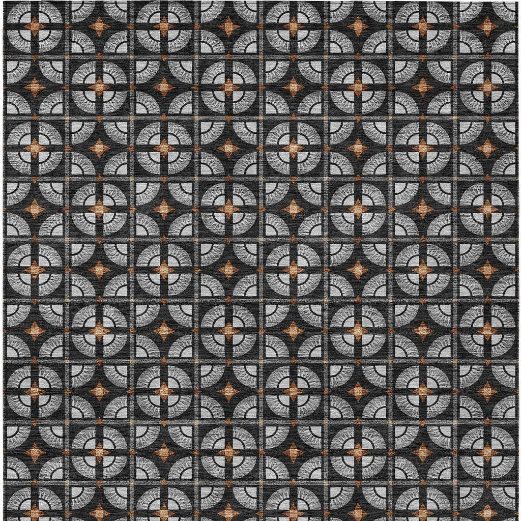 Gray and black geometric patterned fabric with orange accents, perfect for modern upholstery or home decor.