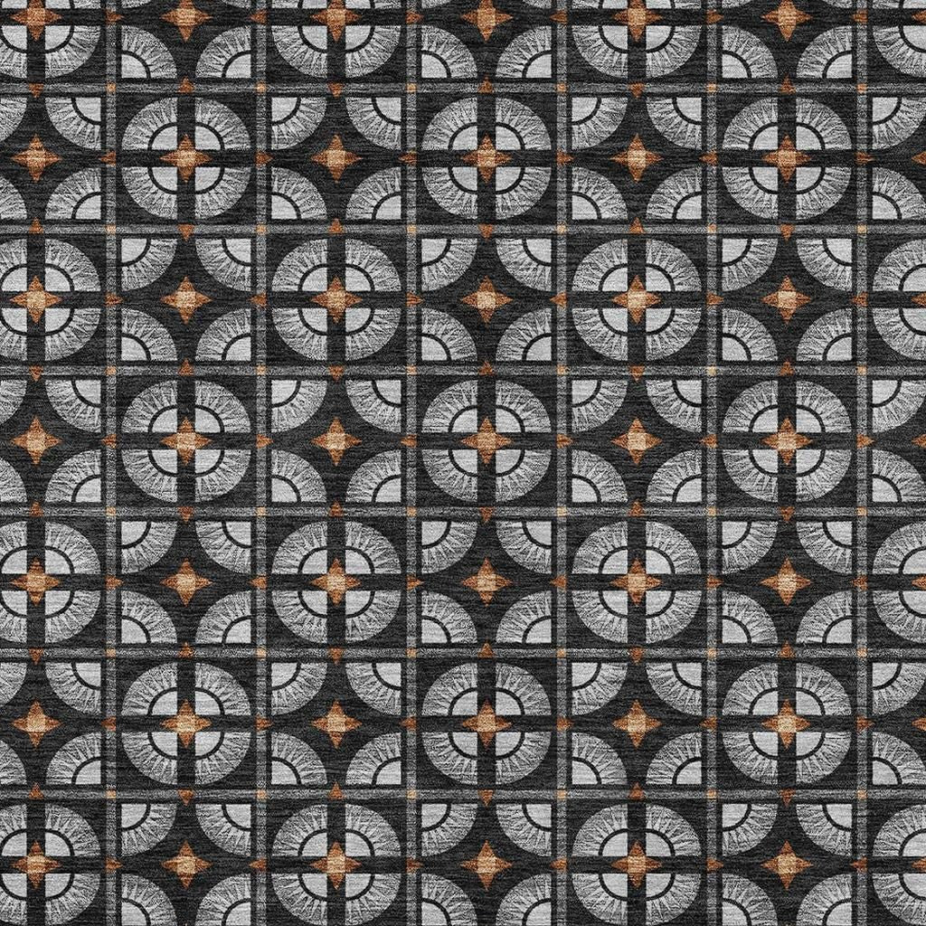 Gray and black geometric patterned fabric with orange accents, perfect for modern home decor projects.