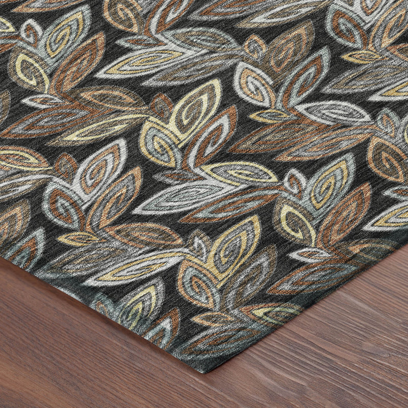 Corner of dark charcoal botanical leaf area rug on wood flooring