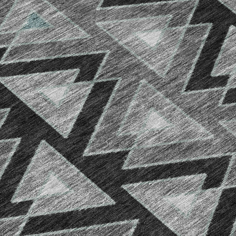 Close-up of gray and dark geometric triangles and zigzag pattern rug surface.