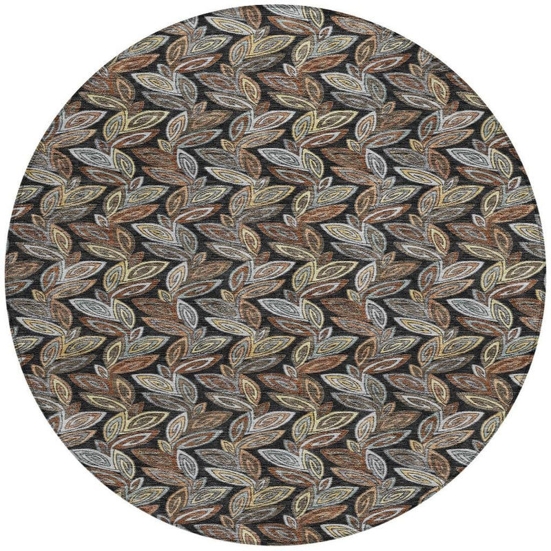 Round botanical leaf pattern area rug with charcoal background and tan, gray, gold accents