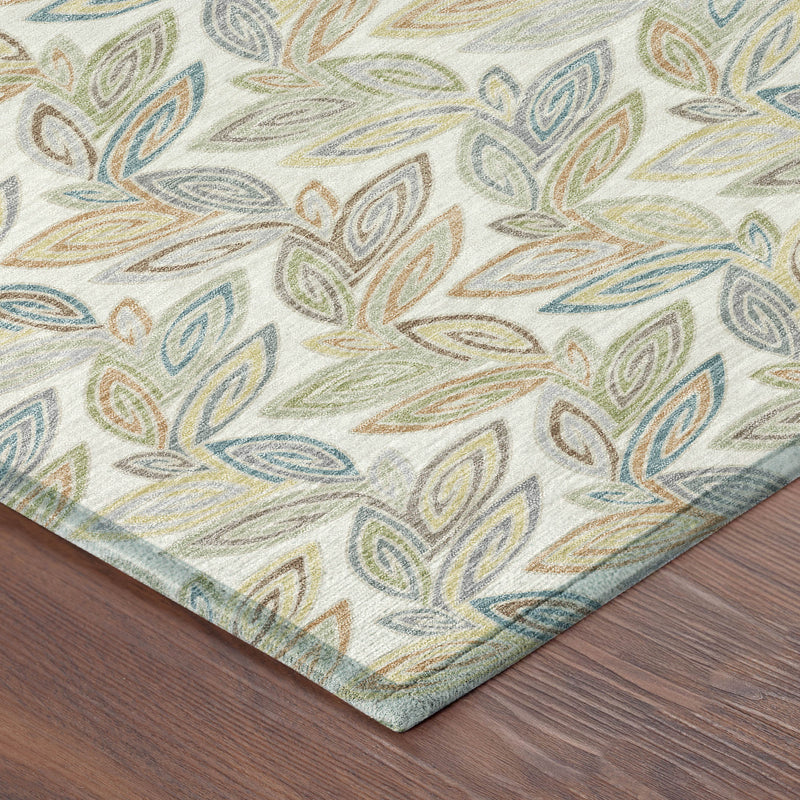 Corner of ivory botanical leaf area rug with blue and green leaf pattern edge.