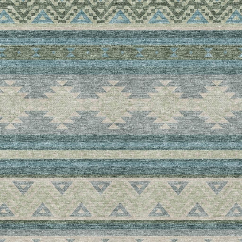 Teal blue and beige rug close-up with repeating triangles, lines, and medallion shapes.