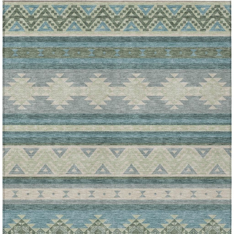 Close-up teal blue and beige area rug with horizontal bands and zigzag triangles.