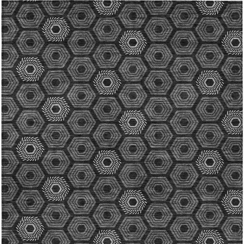 Black and gray geometric rug with repeating hexagon outlines and ring accents