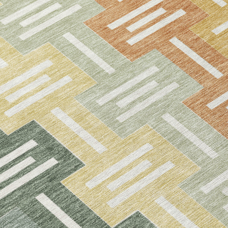 Round rug close-up with green, gold, cream, and white geometric accents