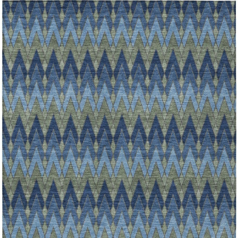 Close-up chevron pattern area rug in blue with green accents, woven texture