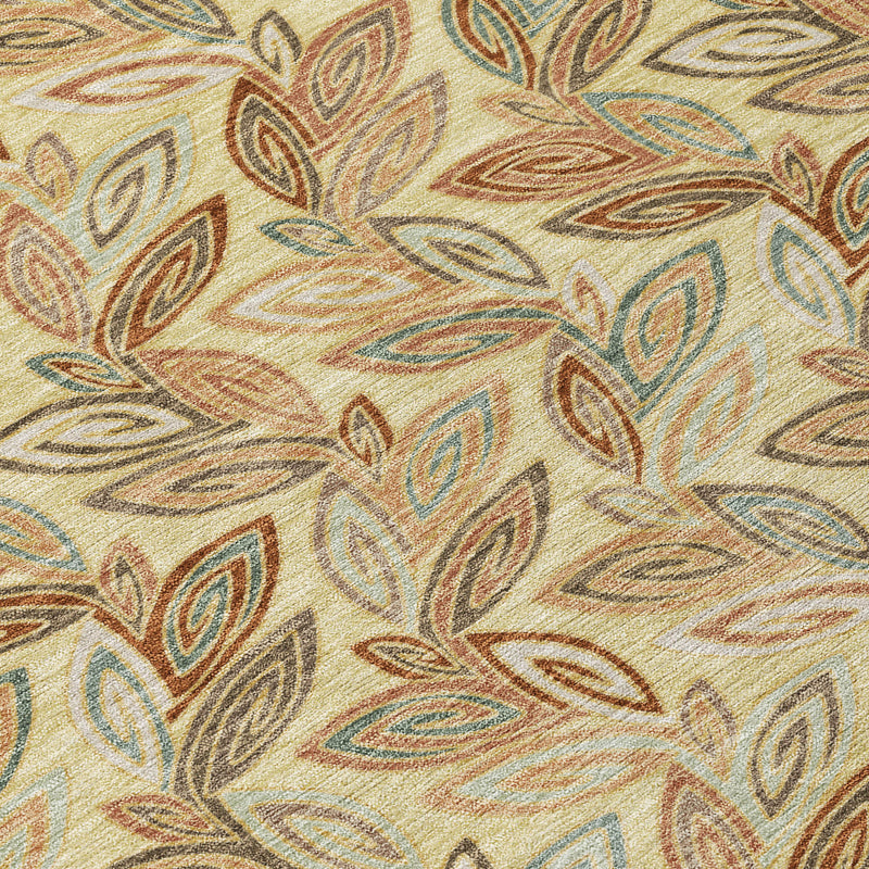 Close-up of botanical leaf pattern on round area rug in wheat, blue, and gold