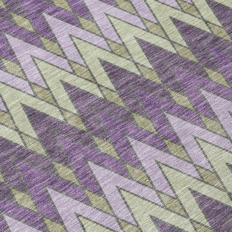 Textured close-up of purple and cream geometric chevron area rug with muted green