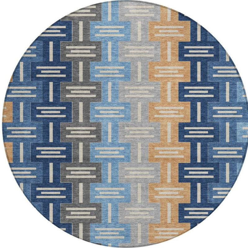 Round area rug with geometric block design in navy blue, sky blue, tan, and gray.