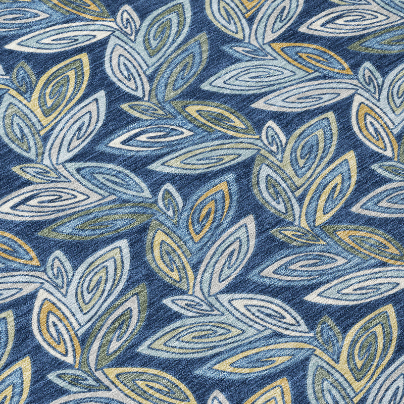 Close-up of navy rug with leaf pattern in light blue, tan, and yellow-green