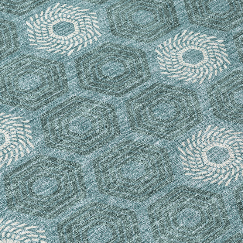 Teal blue area rug close-up with ivory rosette medallions on hexagonal texture