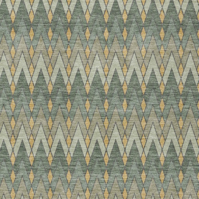 Green and gold geometric area rug close-up with repeating arrow-like chevrons.
