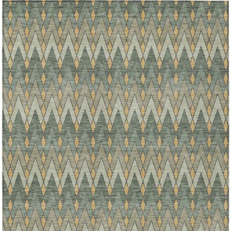 Green and gold geometric area rug close-up showing woven texture and repeating pattern.