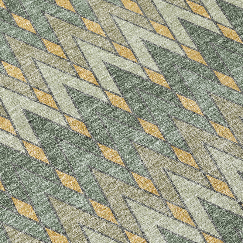 Close-up green area rug with gold, ivory, and blue-gray chevron diamond pattern.