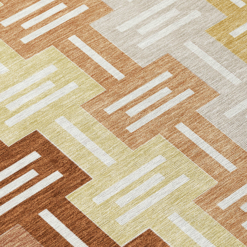 Close-up of geometric area rug pattern in orange, copper, pale yellow, and white