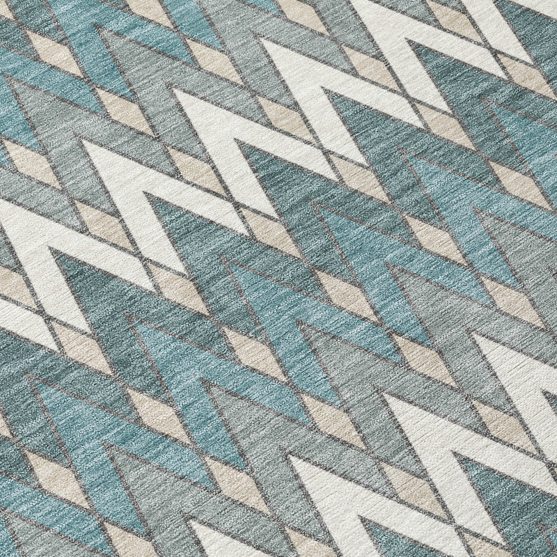 Close-up teal blue area rug with ivory arrow-and-chevron geometric pattern